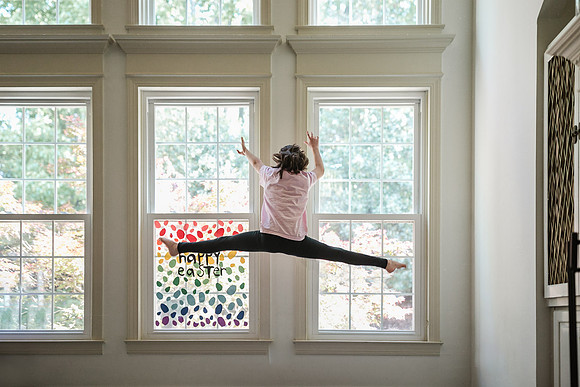 girl doing a straddle jump during her home quarantined gymnastics practice