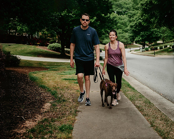 husband and wife taking their dog for a walk during quaratine