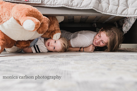 little boy hiding under a bed with his teen sister and stuffed animal