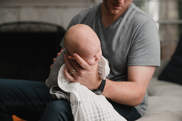 father burping his son at home