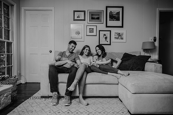 family sitting on their couch laughing together