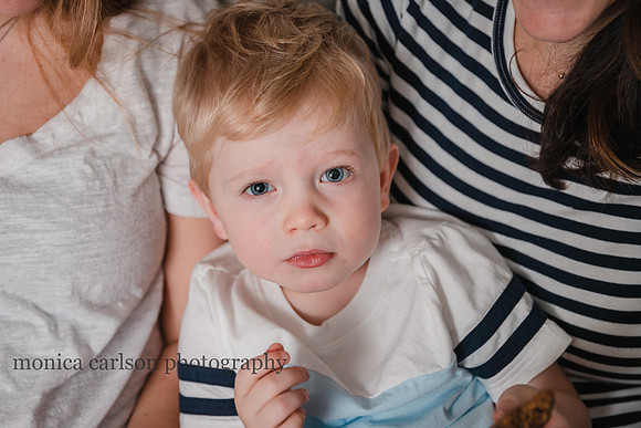portrait of a blonde boy cuddled with his mother and sister during a photo session with monica carlson