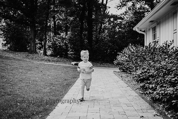 blonde boy running down a path outside his home