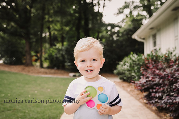 little boy smiling and holding a toy