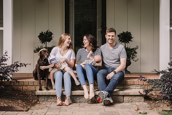 happy family of six sitting on a porch