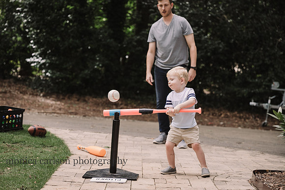 toddler playing t-ball with his father