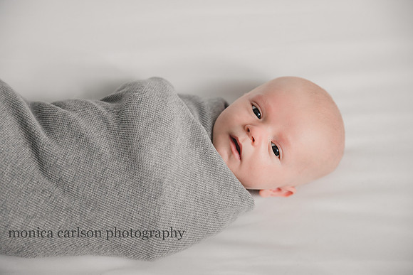 swaddled baby boy laying in his crib