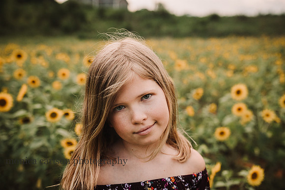 beautiful blonde girl by a sunflower field
