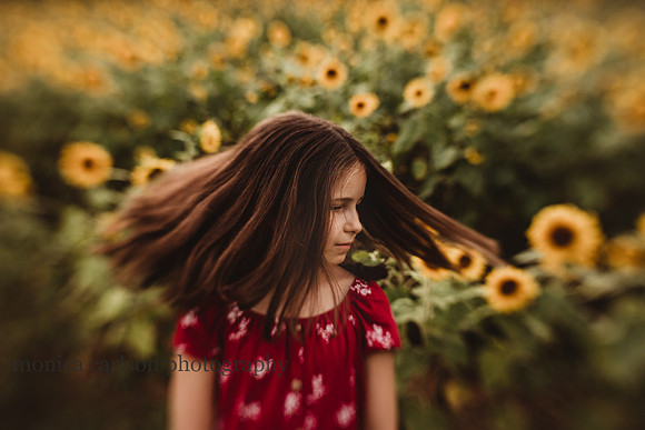 tween girl spinning in a field of sunflowers during a photo session