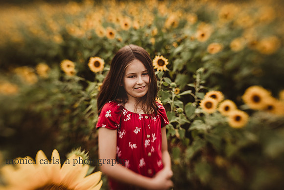 happy girl on a sunflower field by monica carlson photography