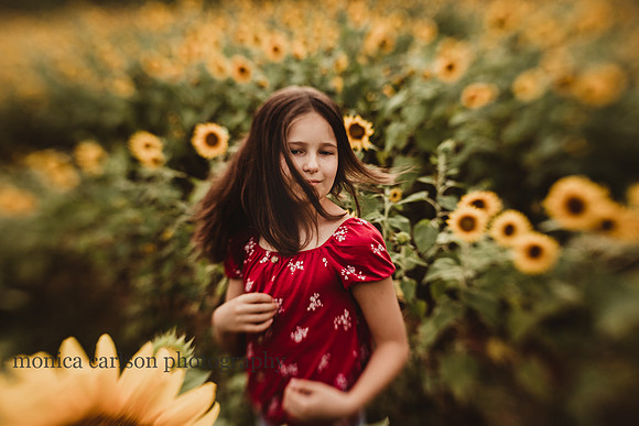 the breeze blows the hair of a tween girl on a sunflower field