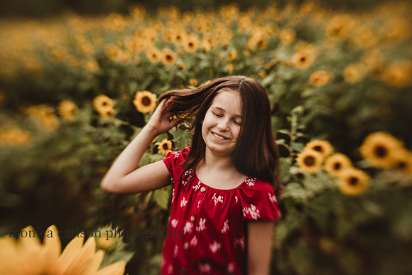 tween girl brushes hair out of her face during a photo session with monica carlson