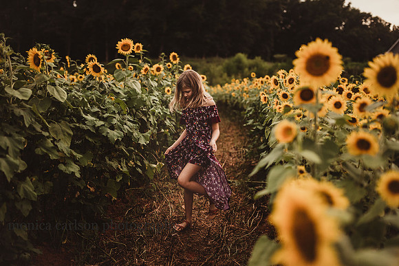 girl walks down rows of sunflowers in cumming, GA