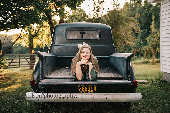 high school senior laying on the bed of a antique bus by monica carlson
