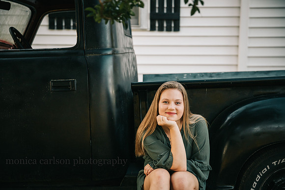 portrait of a teenager sitting on the side of antique truck at Milford family farm in cumming