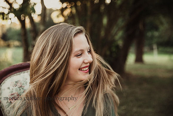 senior photo of a happy girl with her hair blowing around