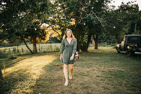 girl walking on a farm during her senior photo session with monica carlson photography