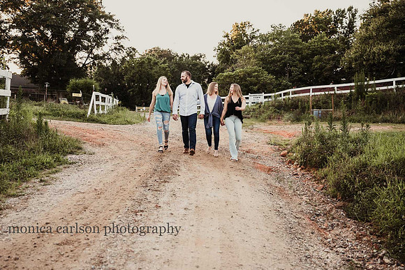 family of four with two teenage girls walking down a dirt road at Milford Family Farm in cumming, GA