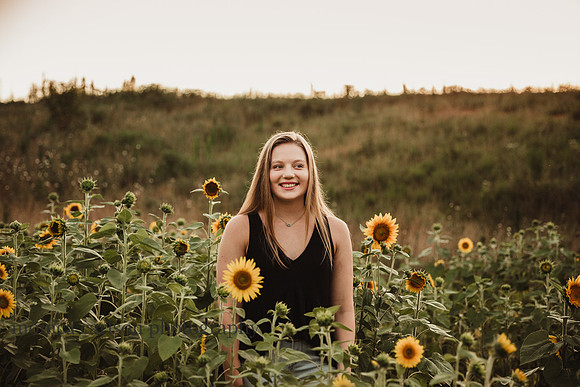 backlit image of a high school senior in a field of sunflowers