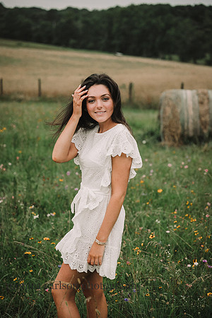 Young woman brushes the wind blown hair from her face