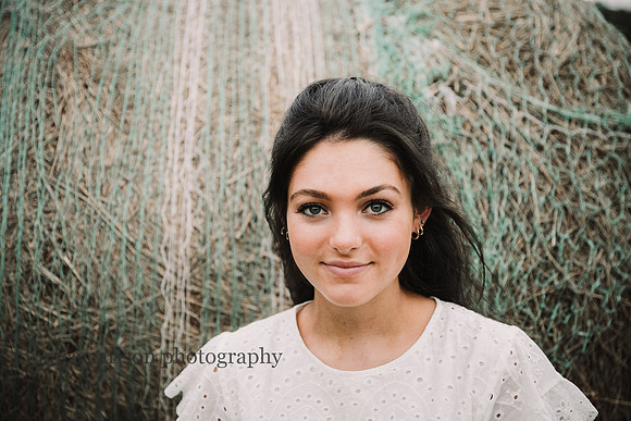 portrait of a teenager in front of a hay bale