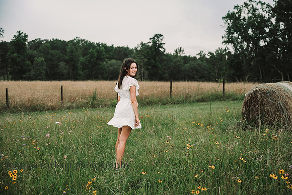 High school senior walking across a wild flower flower field at Prospect Farms