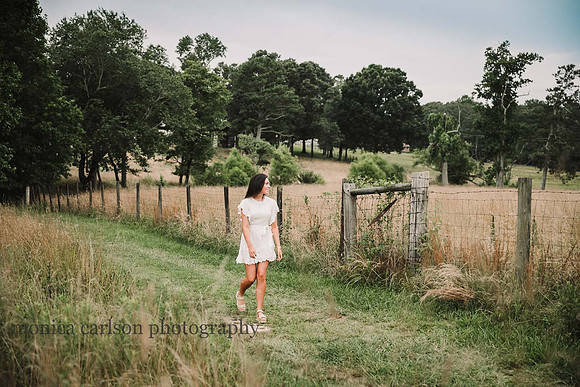 Teenage girl walking along a fence on a farm by monica carlson photography