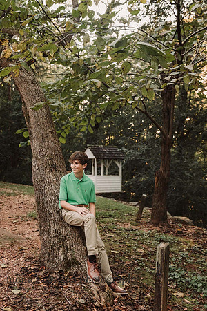 teen boy leaning against a tree in Roswell
