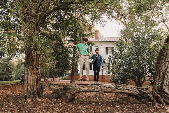 bother and sister jumping from a fallen tree in roswell