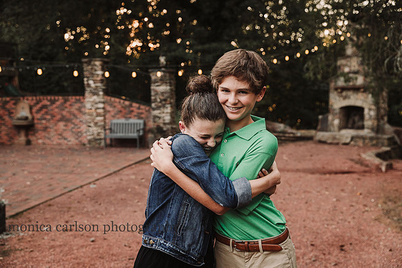 Teen girl hugs her older brother gleefully by monica carlson