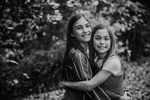 photo of two happy sister hugging in the woods