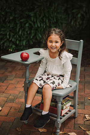 School portrait of a toddler girl in a antique chair