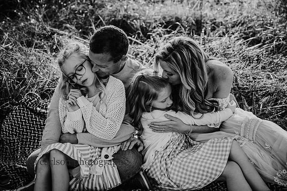 family of four cuddling together on a blanket