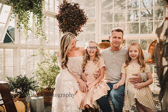 sweet family laughing together in a greenhouse family photo session