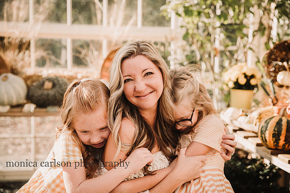 mother squishy her nose while her daughters hug her