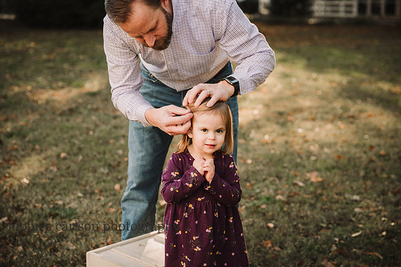 father adjusting his little girls hair