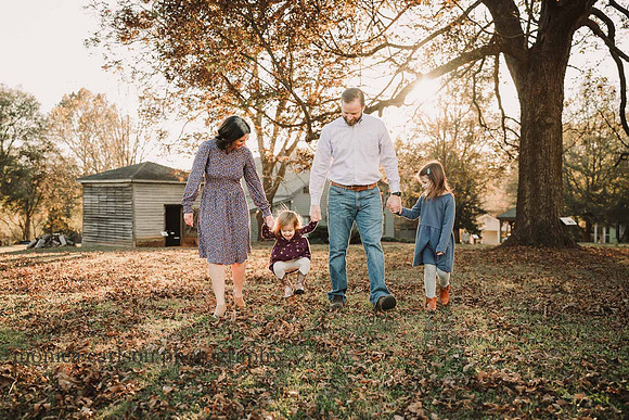 family of four walking in golden light