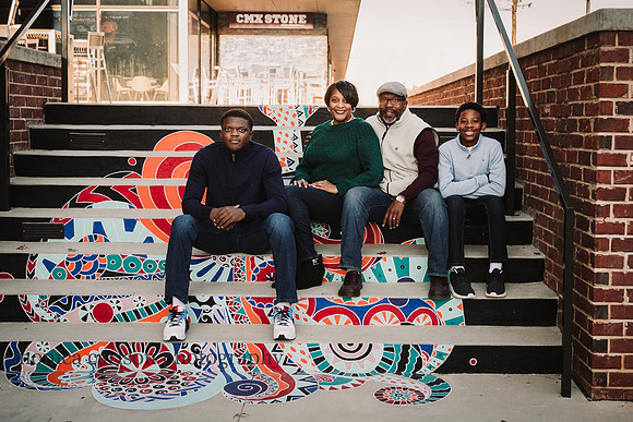 portrait of a african american family sitting on stairs that art has been painted with art