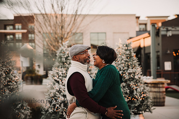 portrait of a happy african american couple in front of christmas trees