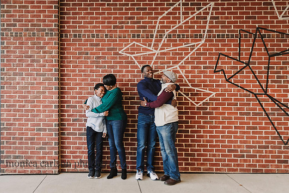 family laughing and hugging during a photo session with Monica carlson