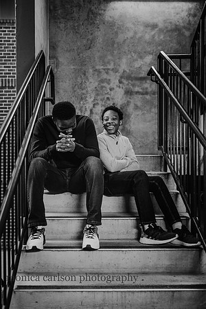 teen, african american boys sitting in a stair well laughing together