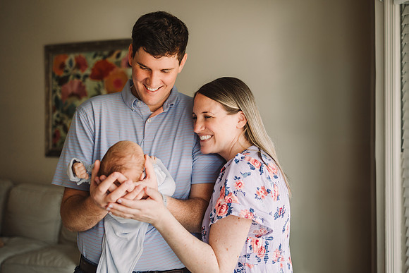 prod parents hold their baby during a newborn session at their home