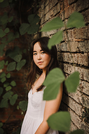 Portrait of a Asian teen girl leaning against a old Mill ruin