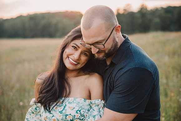 Couple snuggle on a field in Lawrenceville, Georgia