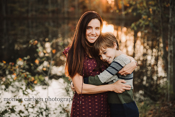 tween boy hugs his mama in front of a lake