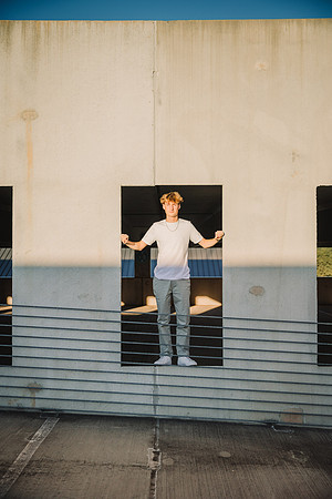 Young man stands in a concrete frame