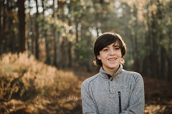 teen boy laughing in a forest