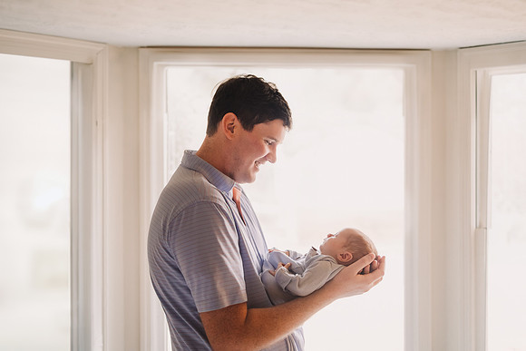 father cradles his new son in his hands