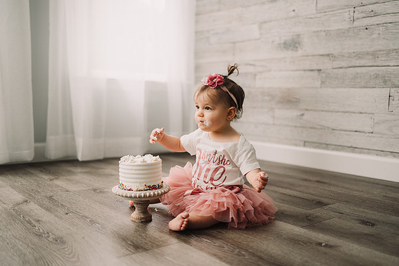 Birthday baby eating her first cake during a photo session