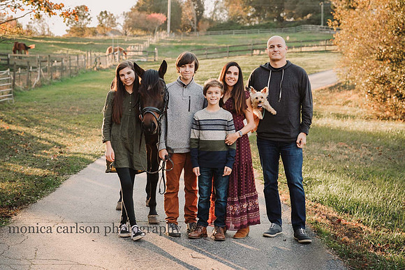family portrait that includes a dog and horse